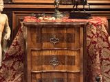 une petite commode surmontée d'une statuette