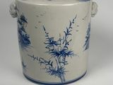 a blue and white vase with a handle on a table