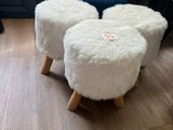 trois tabourets posés sur un plancher en bois