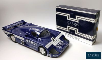 une image représentant une maquette de voiture de course bleue à côté d'une boîte emballée
