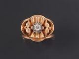 une bague en or avec un diamant au centre, sur un fond noir