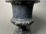 a silver vase that is sitting on a table
