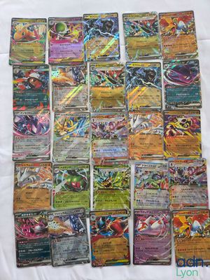 a pile of pokemon cards sitting on top of a white sheet