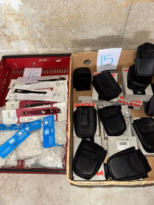 une boîte remplie de téléphones portables et d'autres objets, posée par terre