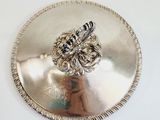 a silver plate with a silver ring on top of it