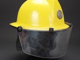 a close up of a yellow hard hat with a clear face shield