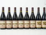 six bouteilles de vin sont alignées sur une surface blanche