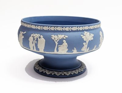 un vase bleu orné de motifs blancs, posé sur une surface blanche