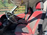 the interior of a van with red and black seats and a steering wheel