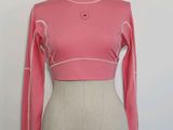 haut rose à manches longues orné de petits pois blancs, présenté sur un mannequin, un mannequin, un mannequin, un mannequin, un mannequin, un mannequin, un mannequin