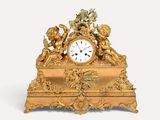 a gold clock with angels on it on a white background
