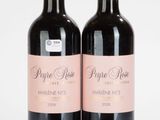 deux bouteilles de vin rouge posées l'une à côté de l'autre sur une surface blanche
