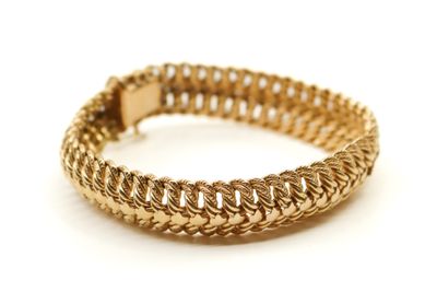 gros plan d'un bracelet en or sur fond blanc