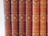 several old books are lined up in a row on a table