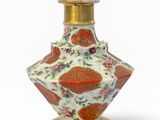 une image représentant un vase rouge et blanc posé sur un socle doré