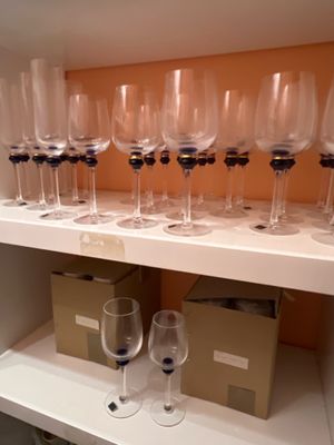 de nombreux verres à vin vides posés sur une étagère dans une pièce