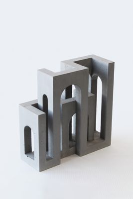 une petite sculpture composée de blocs de béton posés sur une surface blanche
