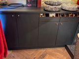 an image of a kitchen with wooden floors and black cabinets
