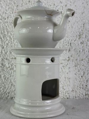 une théière en céramique blanche ornée d'un oiseau