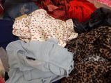 a pile of clothes sitting on top of a bed