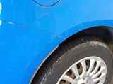 a close up of a blue car with a sticker on it