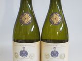 two bottles of white wine sitting next to each other on a table