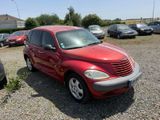 red chrysler ptx parked in a parking lot with other cars in the background