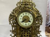 une horloge dorée posée sur une table, sur fond blanc