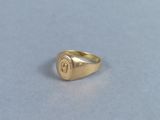 an image of a gold signet ring on a table