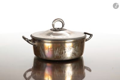 une casserole en argent avec un couvercle, posée sur une table