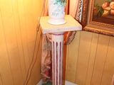 a lamp that is sitting on a pedestal in the corner of a room