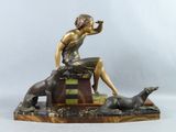 statue d'une femme assise sur une caisse, accompagnée d'un chien