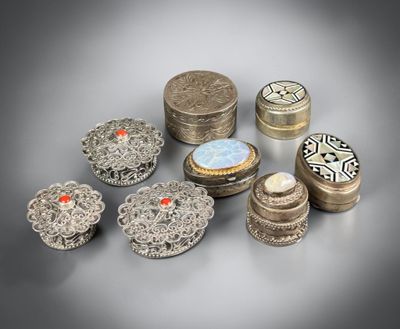 several different types of silver jewelry on a gray surface