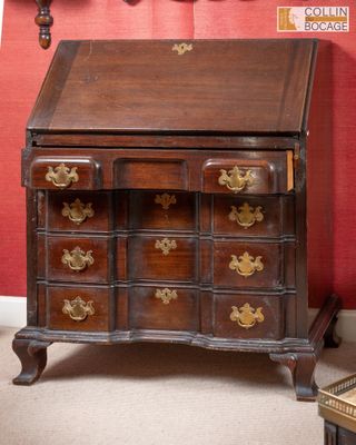 un bureau en bois avec des tiroirs et un miroir accroché au mur