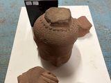 a clay sculpture of a man ' s head and hands on a table