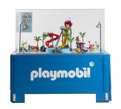 une table Playmobil bleue avec un toboggan aquatique et des figurines