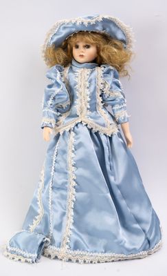 une image représentant une poupée portant une robe bleue et un chapeau