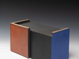 une image représentant une boîte noire, bleue et marron posée sur une surface blanche
