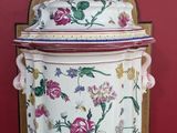 a large vase with a lid sitting on a chair