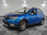 une photo d'une dacia bleue garée sur un sol en damier