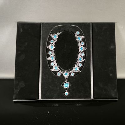 une photo d'un collier et de boucles d'oreilles dans un écrin posé sur une table