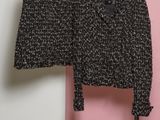 une veste et une jupe en tweed noir et blanc suspendues à un cintre