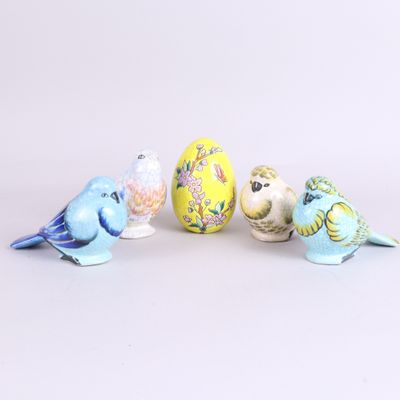 four small birds sitting next to each other on a white surface