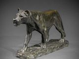 statue en bronze représentant un lion perché sur un rocher, sur fond gris