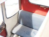 a seat in the back of a bus with a window open