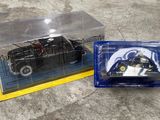 une petite voiture noire dans une boîte transparente posée par terre