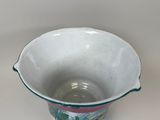 a white bowl with a pink and green design on it