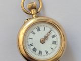 une montre de poche en or avec des chiffres romains