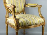 une chaise rayée de jaune et de blanc posée sur un sol gris