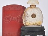 un flacon de parfum posé à côté d'une boîte rouge